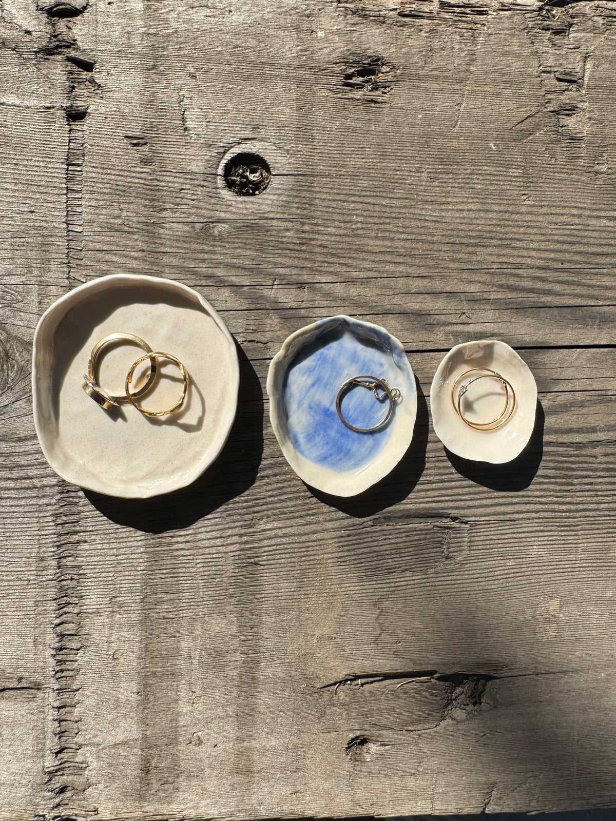 Trio of hand made porcelain mini plates with a selection of gold rings