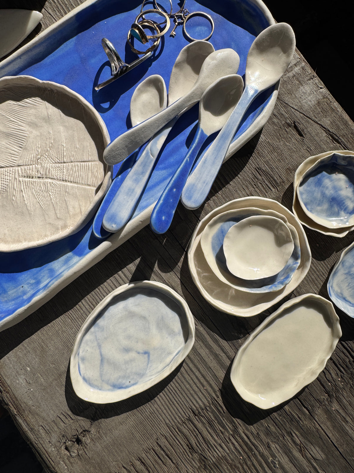 A collection of hand built porcelain plates and spoons