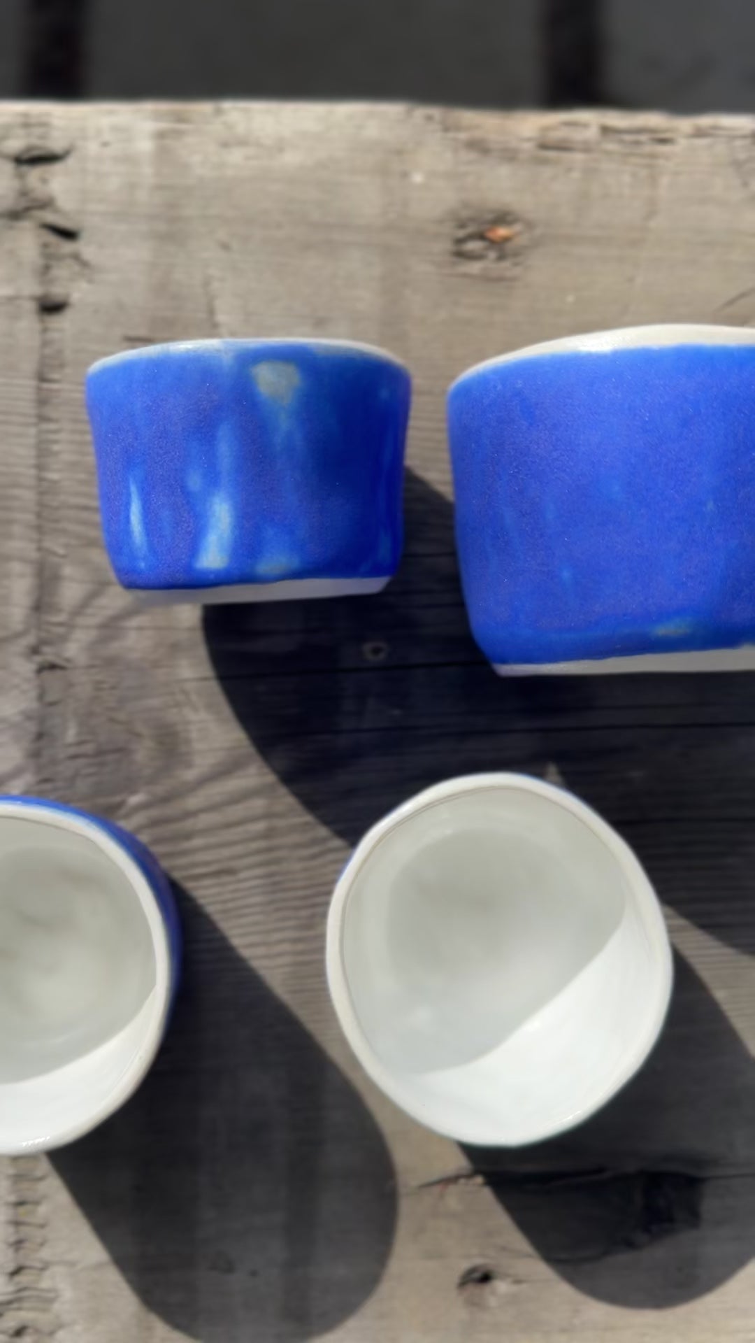 Four porcelain ceramic cups glazed in blue with white interiors